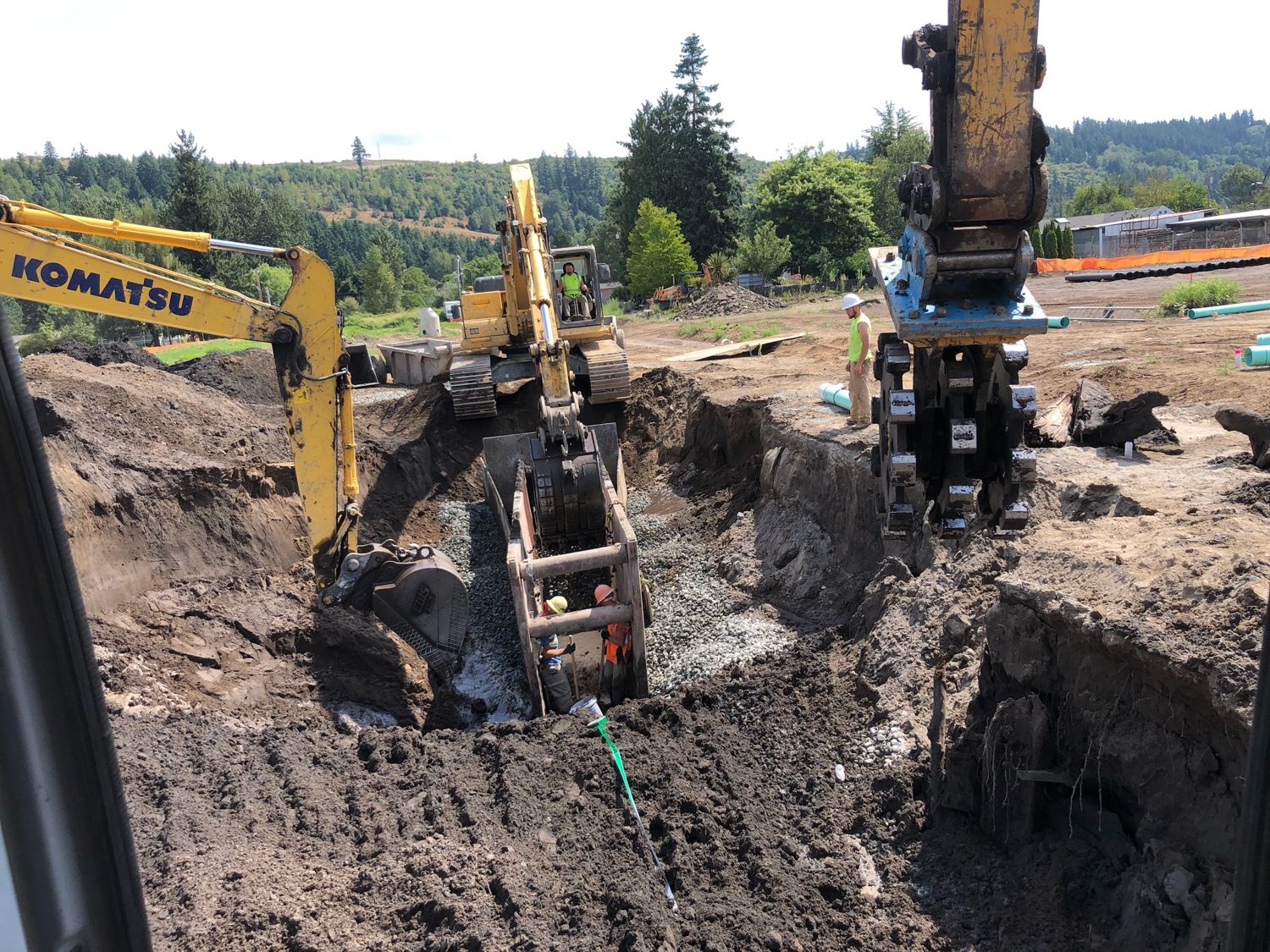 Two excavators working a deep underground utility excavation